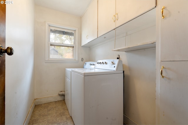 clothes washing area featuring cabinets and separate washer and dryer