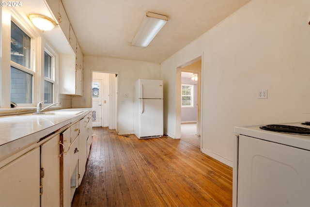 kitchen featuring sink, white cabinets, white appliances, and light wood-type flooring