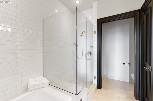 bathroom featuring toilet and separate shower and tub