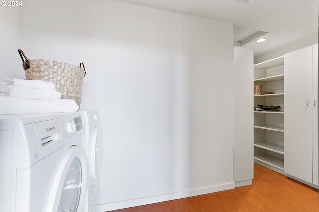 washroom featuring washing machine and dryer and light hardwood / wood-style floors