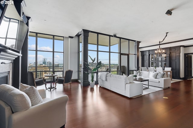 living room featuring a tile fireplace, dark wood-type flooring, a chandelier, and expansive windows