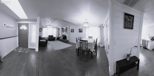 dining room with dark wood-type flooring and lofted ceiling