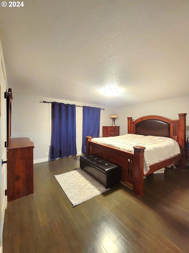 bedroom featuring a textured ceiling and dark wood-type flooring