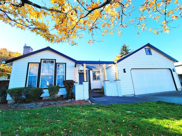 ranch-style house with a garage and a front lawn