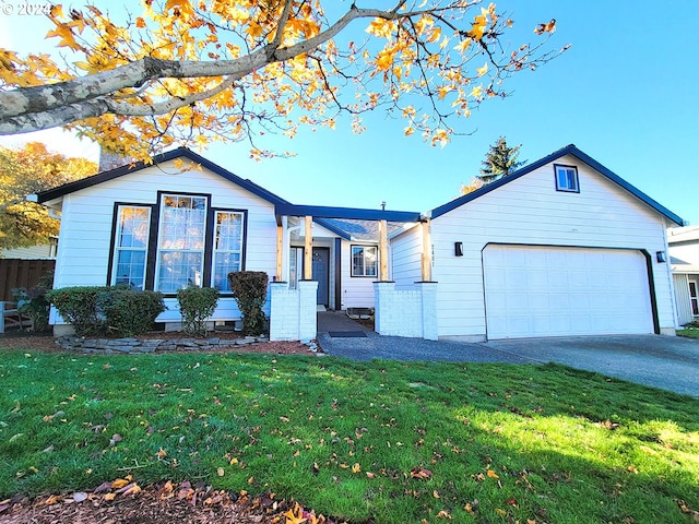 ranch-style home with a garage and a front lawn