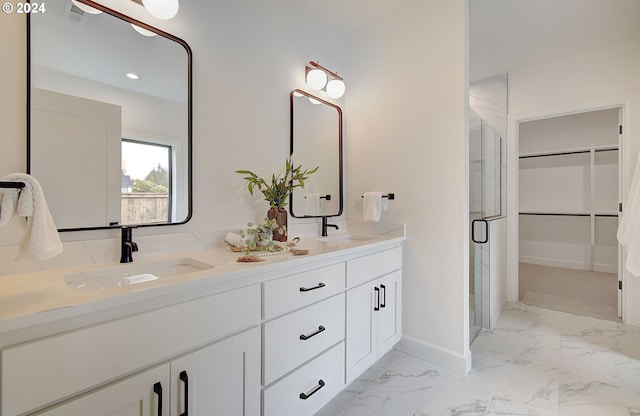 full bathroom featuring a stall shower, marble finish floor, a sink, and double vanity