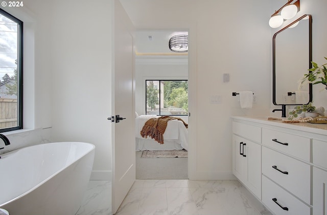 full bathroom with marble finish floor, ensuite bath, a freestanding bath, and vanity