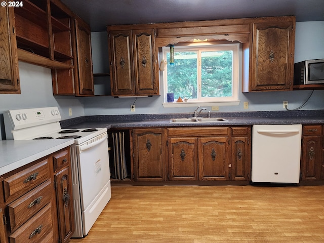 kitchen featuring light hardwood / wood-style floors, dark brown cabinetry, white appliances, and sink