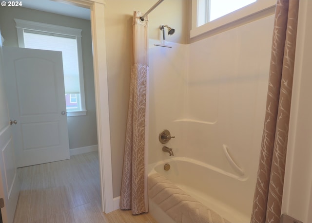 bathroom with shower / bath combo and hardwood / wood-style floors