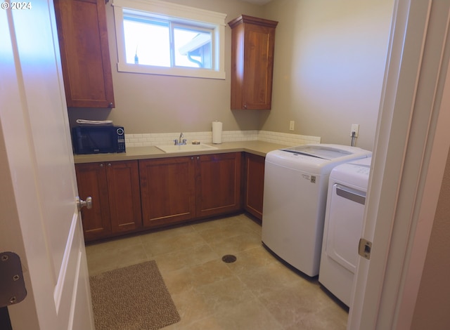 laundry room featuring cabinets, sink, and independent washer and dryer