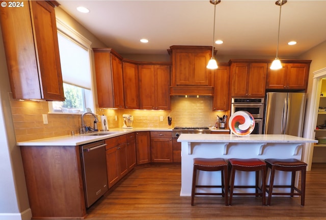 kitchen with a kitchen bar, dark hardwood / wood-style flooring, a center island, sink, and appliances with stainless steel finishes