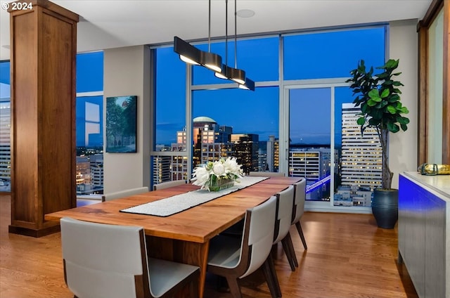 dining room with a wall of windows and hardwood / wood-style flooring