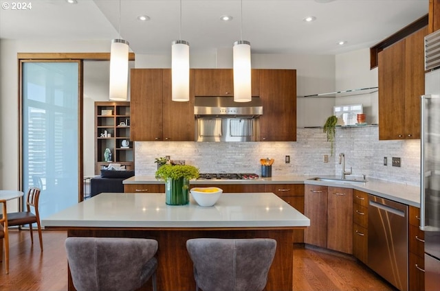 kitchen featuring sink, a kitchen island, hanging light fixtures, and appliances with stainless steel finishes