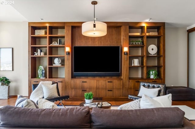 living room with built in features and hardwood / wood-style floors