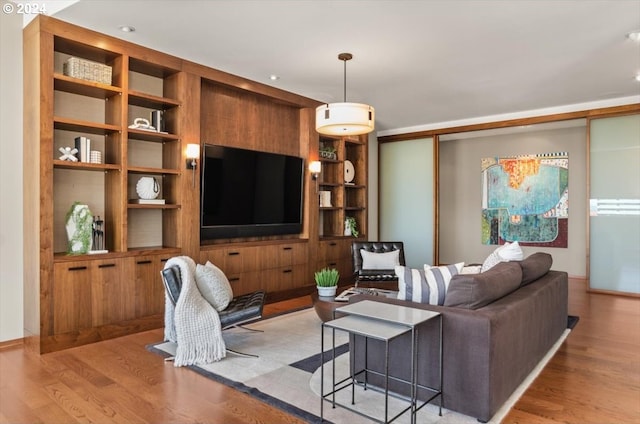 living room with light wood-type flooring and built in shelves