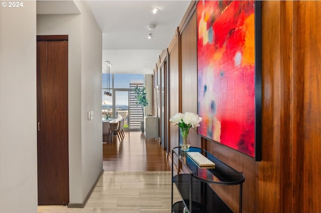 hallway featuring light wood-type flooring and expansive windows