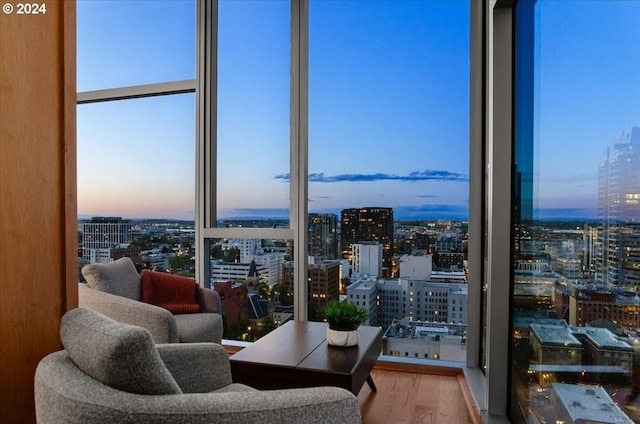 living room with a wall of windows, hardwood / wood-style floors, and a healthy amount of sunlight