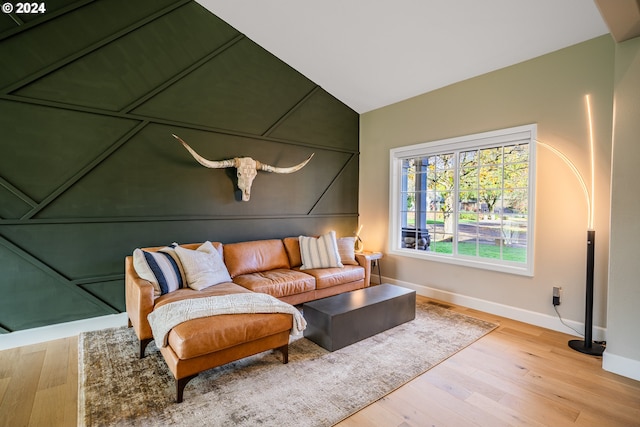 living room featuring vaulted ceiling, wood finished floors, and baseboards