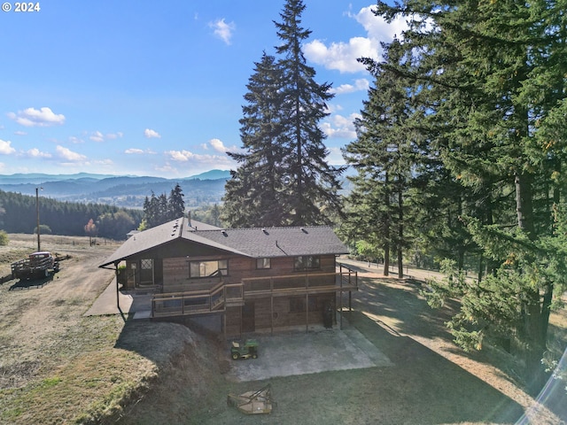 rear view of property with a mountain view and a patio