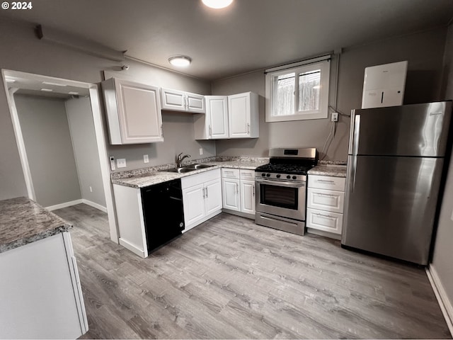 kitchen with white cabinets, sink, light wood-type flooring, light stone counters, and stainless steel appliances