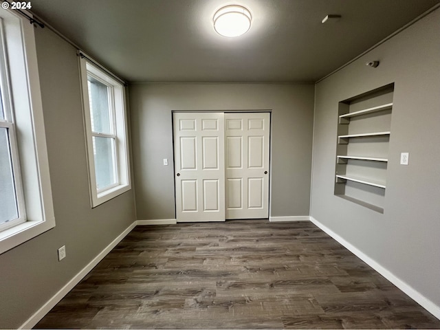 unfurnished bedroom with dark hardwood / wood-style floors and multiple windows