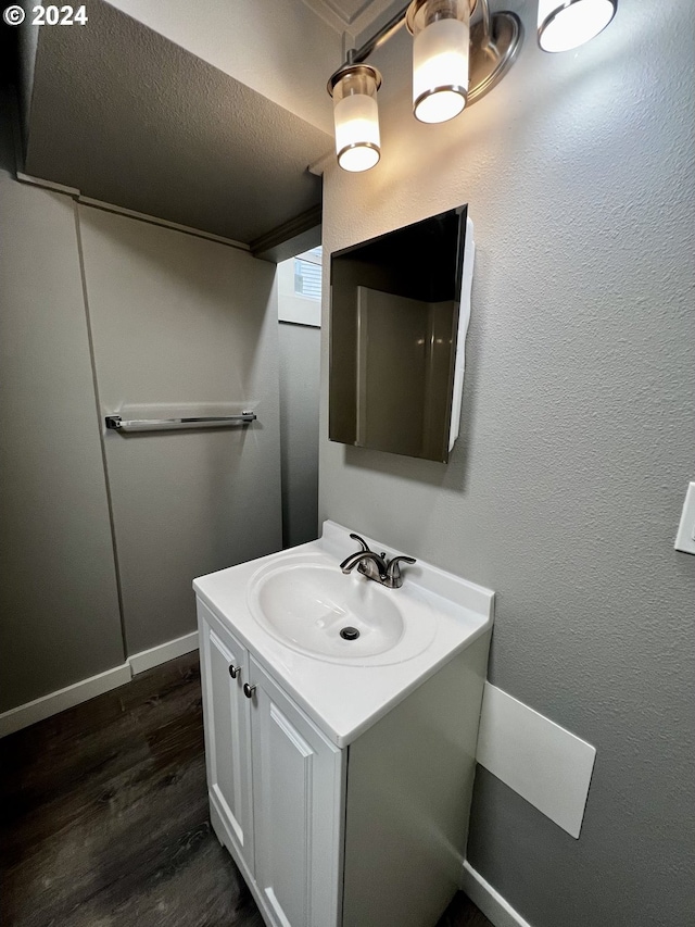 bathroom featuring vanity, wood-type flooring, and a textured ceiling