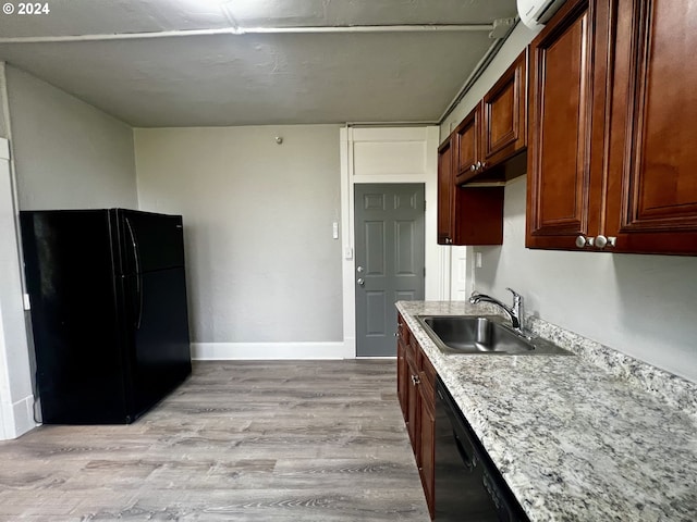 kitchen featuring black appliances, sink, and light hardwood / wood-style flooring