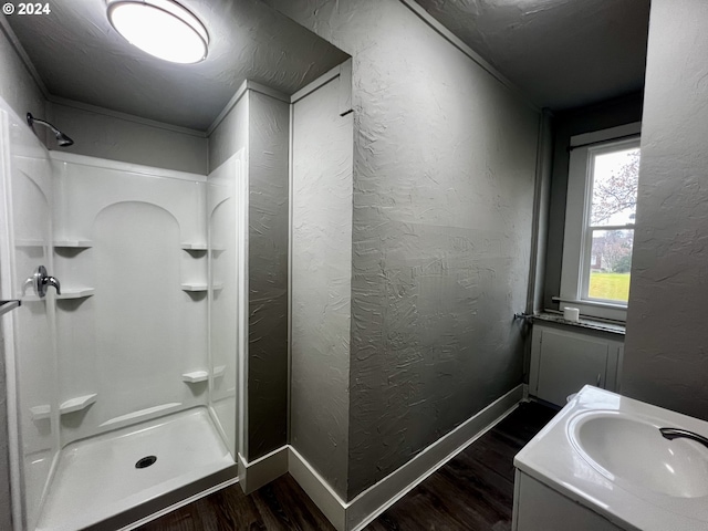 401 NW Bailey Ave, Pendleton, OR 97801 - bathroom with wood finished floors, a shower stall, a textured wall, vanity, and baseboards
