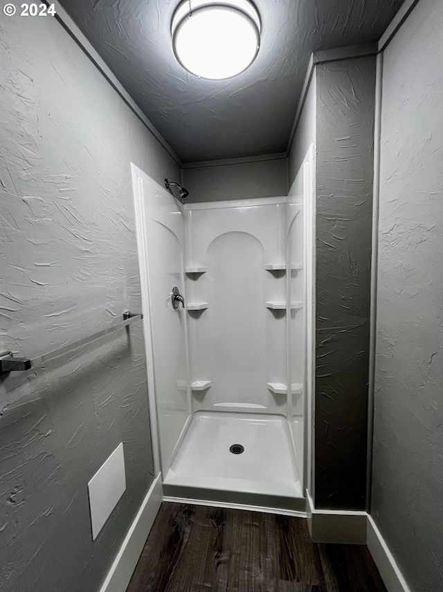 bathroom with hardwood / wood-style flooring and walk in shower