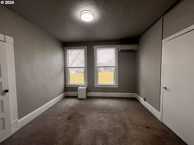 unfurnished room with carpet floors, a textured ceiling, and a wall mounted AC