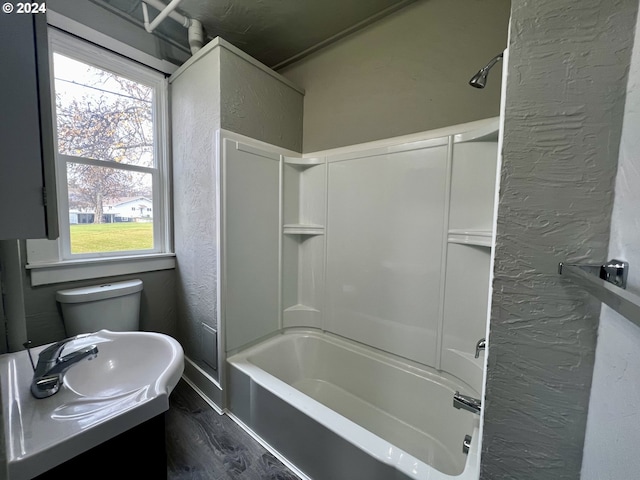 full bathroom featuring hardwood / wood-style floors, vanity,  shower combination, and toilet