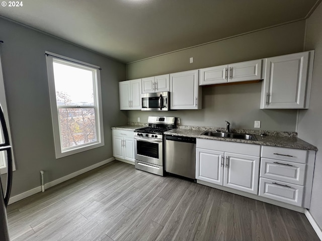 401 NW Bailey Ave, Pendleton, OR 97801 - kitchen featuring appliances with stainless steel finishes, a sink, white cabinetry, and light wood-style flooring