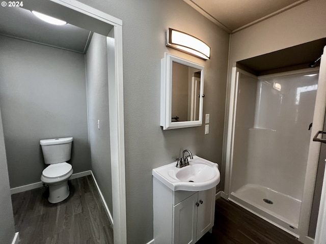 bathroom featuring hardwood / wood-style floors, vanity, toilet, and walk in shower