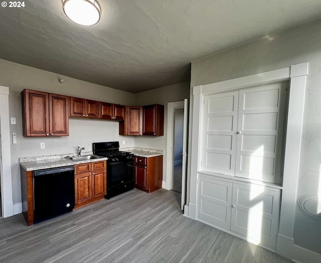 kitchen with black appliances, light hardwood / wood-style floors, and sink