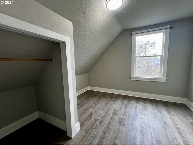 bonus room with light hardwood / wood-style floors and vaulted ceiling