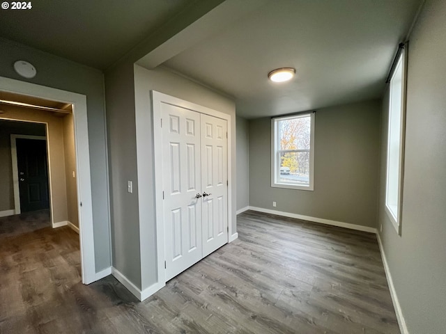 unfurnished bedroom with hardwood / wood-style floors and a closet