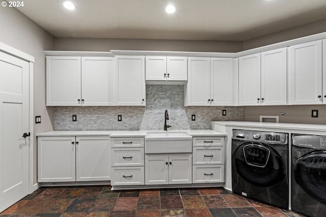 laundry area featuring cabinets, sink, and washing machine and clothes dryer