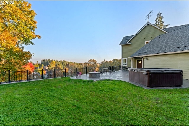 view of yard featuring a hot tub, a fire pit, and a patio