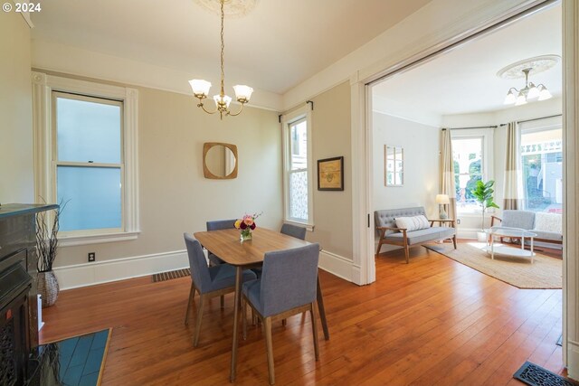 dining room featuring plenty of natural light, an inviting chandelier, and hardwood / wood-style flooring