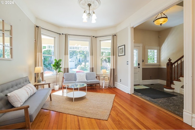 sitting room with a wealth of natural light, an inviting chandelier, and hardwood / wood-style floors