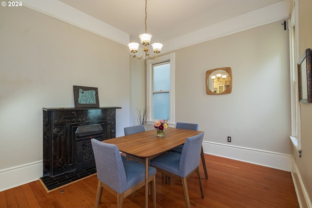 dining room with a high end fireplace, wood-type flooring, and a chandelier