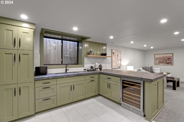 kitchen featuring light carpet, kitchen peninsula, wine cooler, sink, and green cabinetry