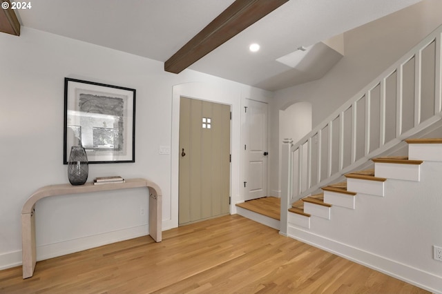 entrance foyer with light hardwood / wood-style floors and beam ceiling