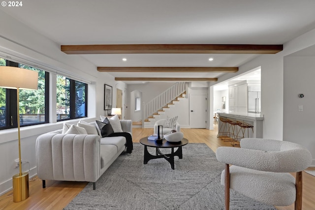 living room with light hardwood / wood-style floors and beam ceiling