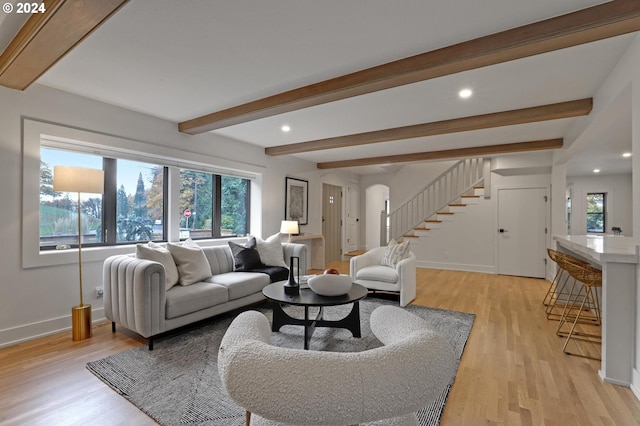 living room with light hardwood / wood-style flooring and beam ceiling