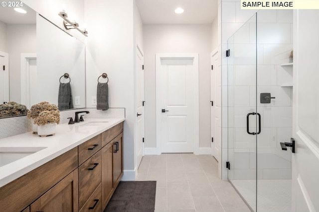 bathroom featuring tile patterned floors, vanity, and a shower with door