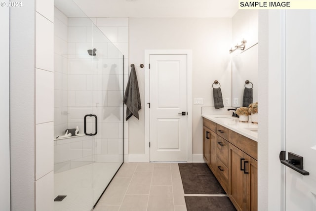 bathroom featuring tile patterned floors, a shower with door, and vanity