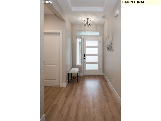 doorway featuring a notable chandelier and light hardwood / wood-style floors