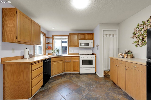 kitchen with a textured ceiling, sink, and white appliances