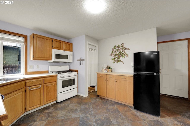 kitchen with sink, white appliances, and a textured ceiling